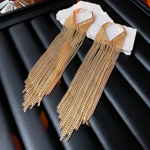 Detailed view of elegant gold metal tassel earrings with V-shape frame on black display