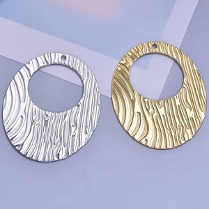 Macro view of gold and silver oval 304 stainless steel pendants with hammered wavy texture