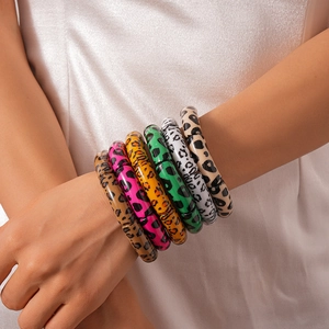 Detail view of a six-piece set featuring leopard print acrylic tube bracelets in multiple colors