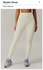 Close-up of creamy apricot high-waisted yoga pants showing matte stretch fabric texture