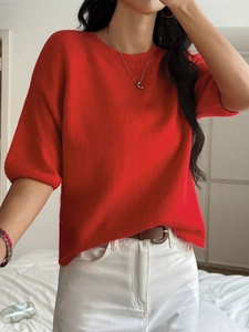 Detail view of red round-neck knit sweater with elegant puff sleeves for a cozy autumn look