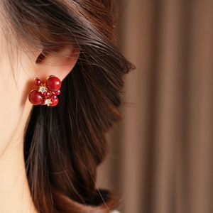 Dettaglio degli orecchini vintage in oro 18K con design floreale in zircone rosso