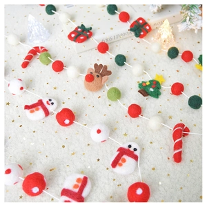 Detail of wool felt Christmas garlands with snowmen, reindeer and trees for holiday decor