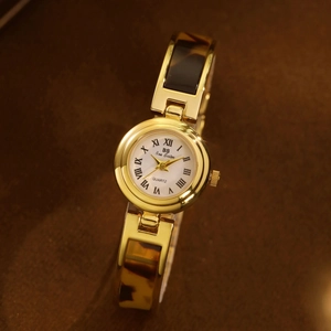 Elegant gold watch for women featuring tortoise shell chain strap and white Roman dial