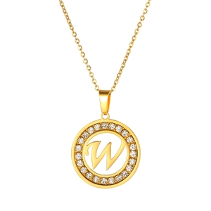 Detail of a gold circular pendant with crystal inlay and a hollow letter W design