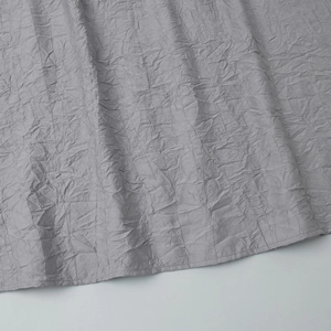 Gros plan sur la texture du tissu gris froissé et couture détaillée de l'ourlet