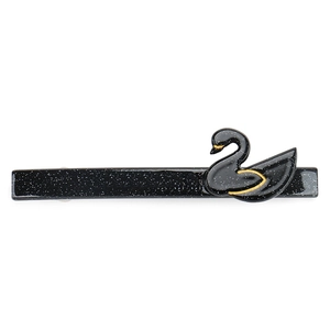 Detail of a black glitter hair clip featuring a 3D swan accent with golden outlines