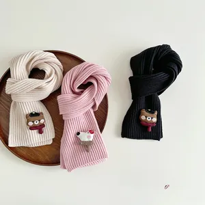 Detail of ribbed knit scarves with cute cartoon animal patches in cream, pink, and black