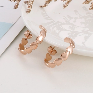 Macro shot of polished rose gold heart hoop earrings with an elegant minimalist finish