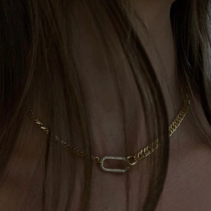 Retro geometric gold choker necklace with a rhinestone pendant on a model in low lighting