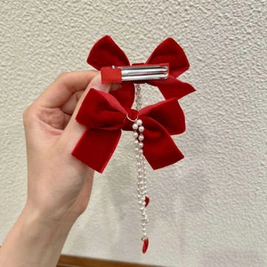 Detail of red velvet bow hair clips with elegant pearl tassels for girls