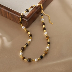 Collier en oeil de tigre et perles avec accents dorés sur fond de soie