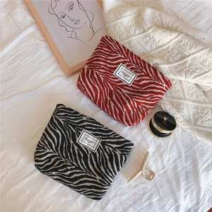 Detail view of zebra pattern makeup bags with TIME TO PARTY logo on woven fabric