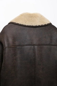 Detailed back view of vintage faux leather jacket with shearling collar and seam details