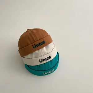 Set di tre berretti docker in cotone per bambini con ricamo Unice e logo sorriso