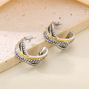 Macro shot of multi-layer woven earrings featuring gold and zircon-set silver bands