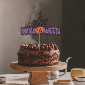 Glittery Halloween cake topper with pumpkin and ghost house on a chocolate cake
