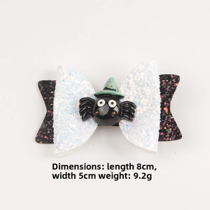 Close-up of Halloween bow hair clip with black glitter spider and green wizard hat