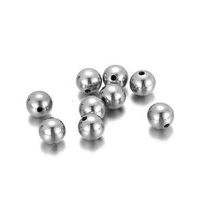Vue macro de perles rondes en acier inoxydable poli avec trou pour la bijouterie