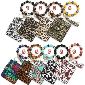 Detail view of colorful silicone bead wristlets and patterned animal print leather wallets