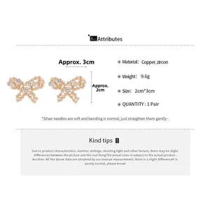 Detailed view of zircon butterfly earrings in gold finish with 2cm x 3cm dimensions