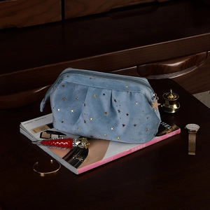 Light blue velvet cosmetic bag with gold star patterns and a star-shaped zipper pull