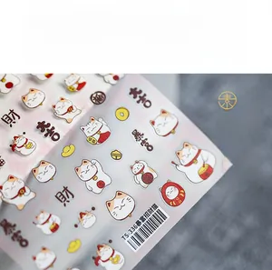 Vue détaillée des stickers ongles 3D du Nouvel An avec chat porte-bonheur et lingots