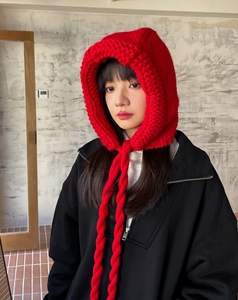 Gros plan détaillé d'une cagoule rouge en maille épaisse avec attaches tressées d'hiver