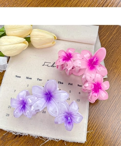 Close-up of pink and purple gradient flower hair clips with a matte resin texture