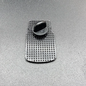 Makroaufnahme der Metallabzeichen-Rückseite mit schwarzem Gummiverschluss und Netzstruktur
