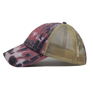 Detail of red and black tie-dye cotton fabric with yellow breathable mesh on a baseball cap