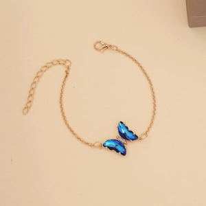 Detail of gold chain necklace with a blue crystal butterfly pendant and diamond accents