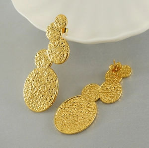 Detailed view of 18K gold plated hammered lava style stainless steel drop earrings