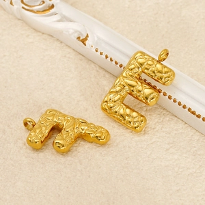 Detailed close-up of golden letter F charms with unique embossed texture for jewelry