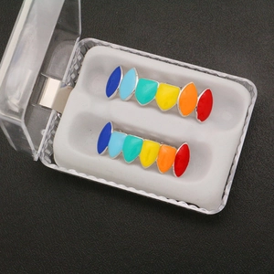 Rainbow colored hip hop teeth grills in a clear storage box over black background