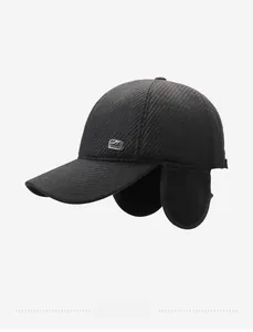 Side view of dark gray winter baseball cap with ear flaps and fashion logo patch