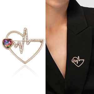 Gold heart and heartbeat brooch with rainbow rhinestones on white and suit background