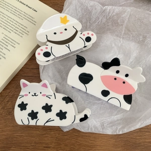 Three cute animal hair claws including white dog, panda, and cat on wooden background