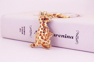 Detail of golden leopard keychain with heart cutouts and blue crystals on book