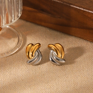 Stylish gold and silver twisted hoop earrings displayed on a rustic linen background
