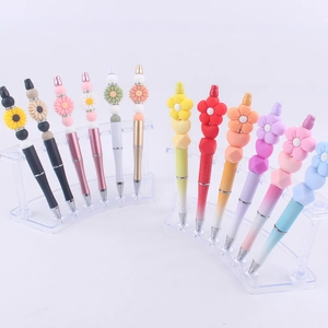 DIY colorful beaded pens set with sunflower silicone beads displayed on acrylic stands