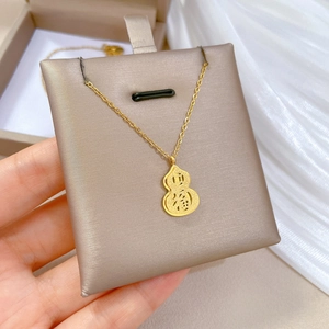 Close-up of gold-plated titanium gourd necklace featuring Fu character and coin engraving