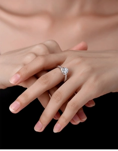 Close-up of a S925 sterling silver four-prong moissanite ring worn on a finger