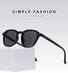 Detail of glossy black square-frame sunglasses with silver double dot rivets and dark lenses