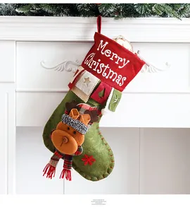Classic red and green Christmas stocking with 3D reindeer doll hanging on a white fireplace