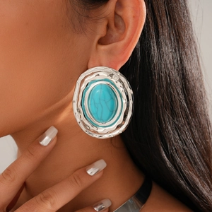 Detail of silver-framed blue marble resin earrings with vintage textured metal edges