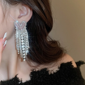 Close-up of sparkling heart tassel earrings with silver finish and pavé crystal fringes