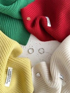 Dettaglio della trama in lana lavorata a maglia e dell'etichetta fatta a mano multicolore