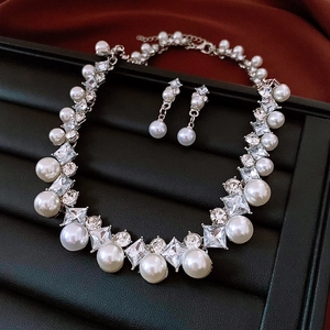 Nahaufnahme eines luxuriösen Schmucksets mit Perlen und Strass auf einer Geschenkbox