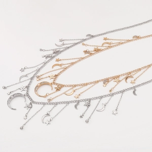 Detailed close-up of layered necklace with star and moon charms and rhinestone tassels